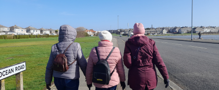 Three women walking facing away from the camera